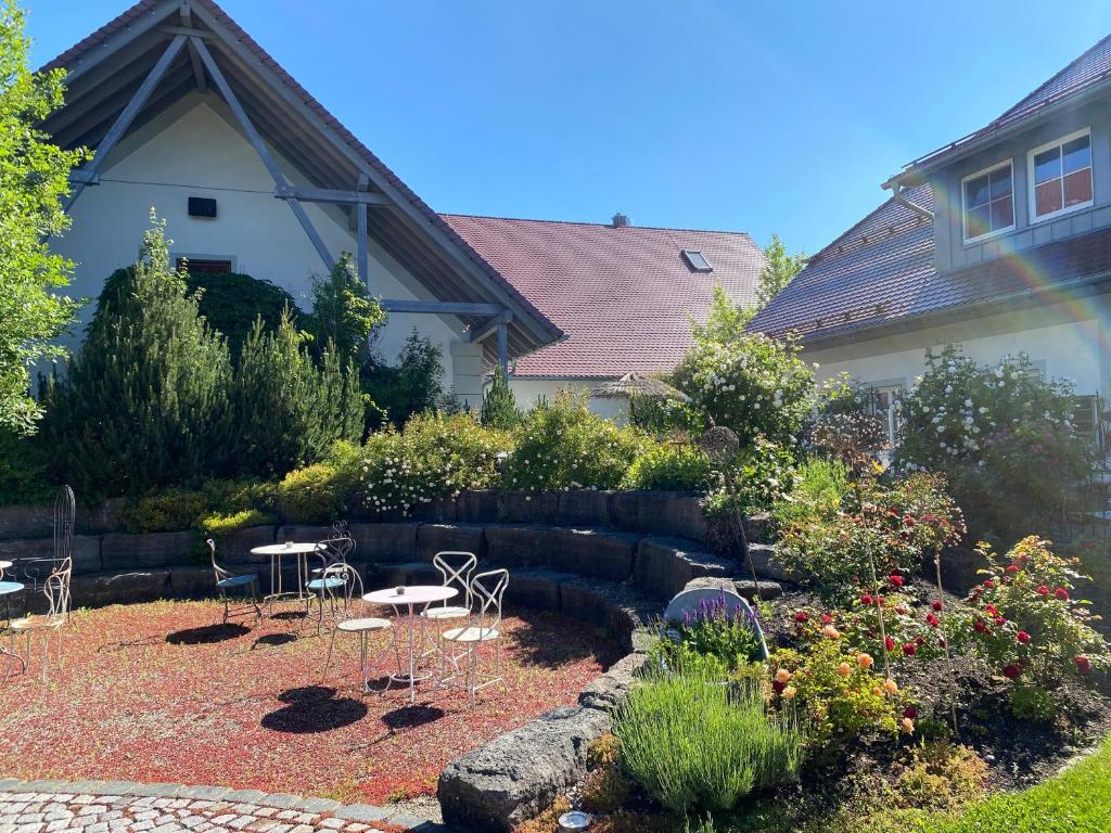 un jardín con sillas y mesas y una casa en Riffelhof, en Burgrieden