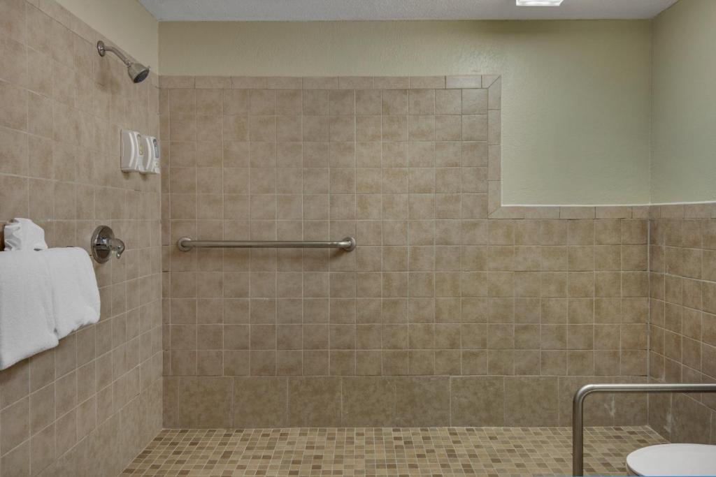 a bathroom with a shower with a tiled shower at Baymont by Wyndham Panama City Beach in Panama City Beach