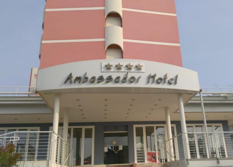 un edificio con un cartel de hotel americano en él en Hotel Ambassador, en Caorle