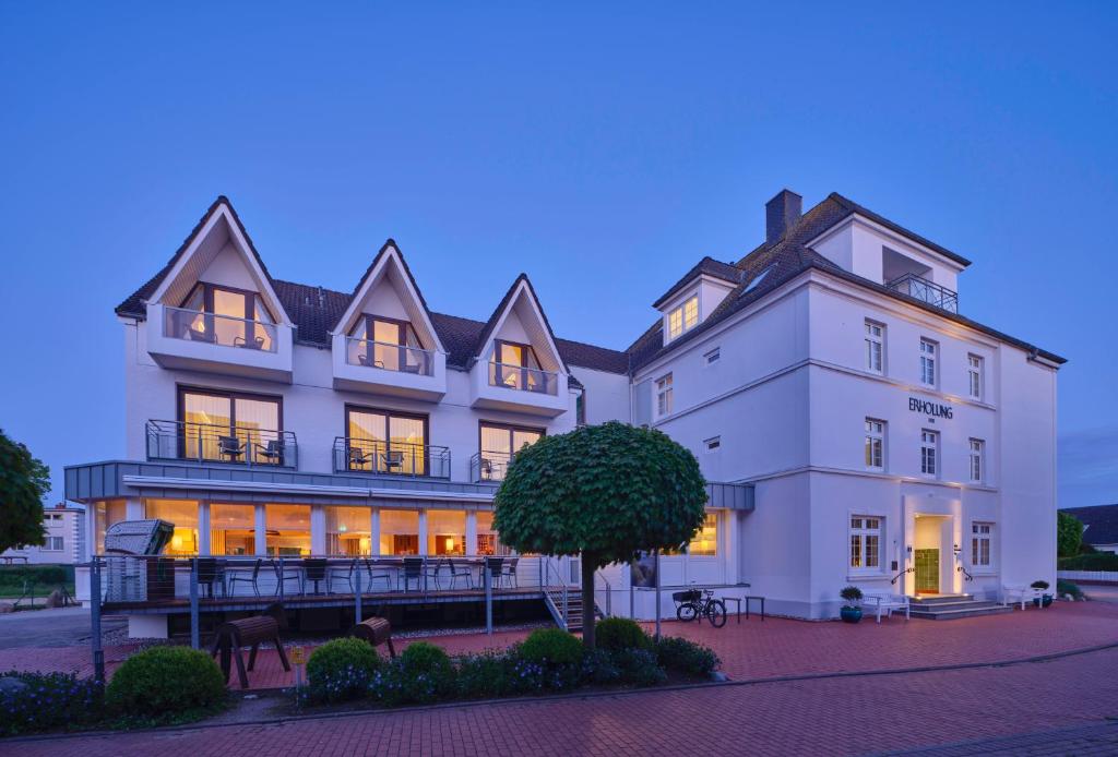 un gran edificio blanco con luces encendidas en Hotel Erholung, en Kellenhusen