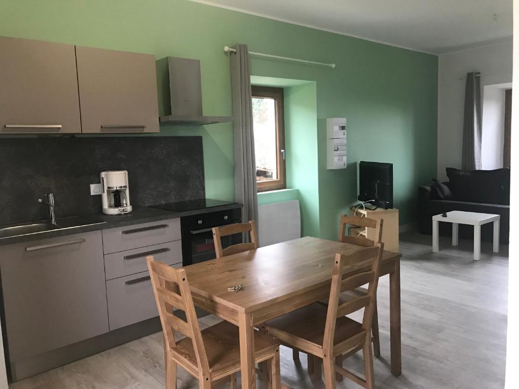 a kitchen with a wooden table and chairs in a room at Les Granges du Pichat in Froges