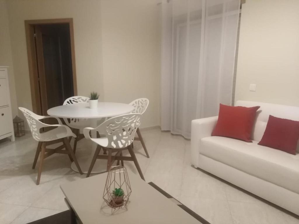 ein weißes Wohnzimmer mit einem Tisch und einem Sofa in der Unterkunft Almancil Park Apartment in Almancil