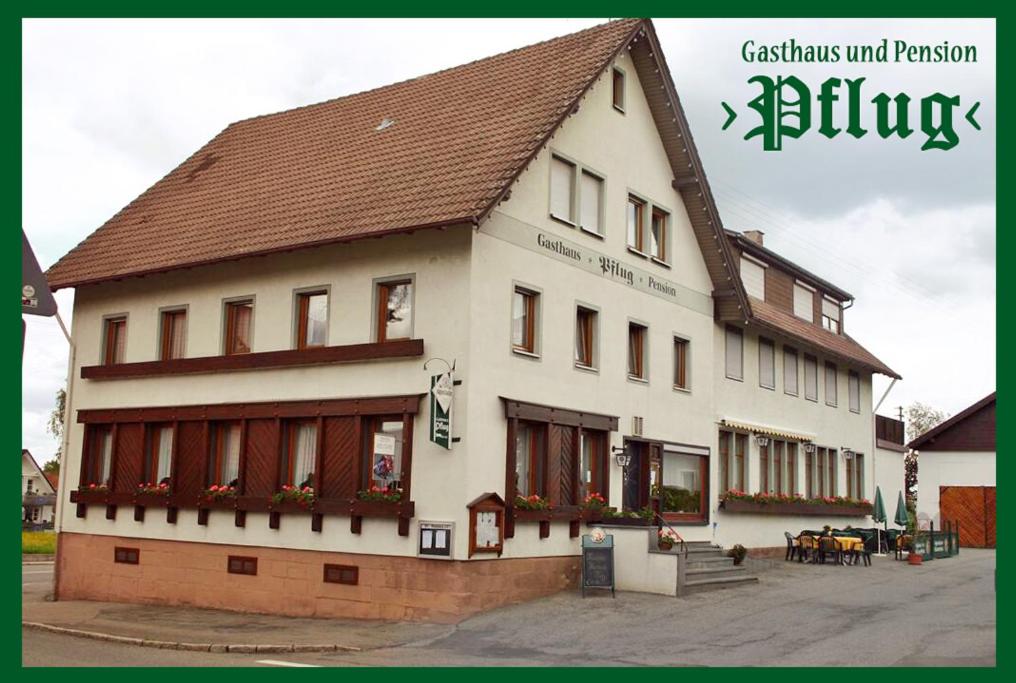 にあるGasthaus Pflugの茶色の屋根の白い大きな建物