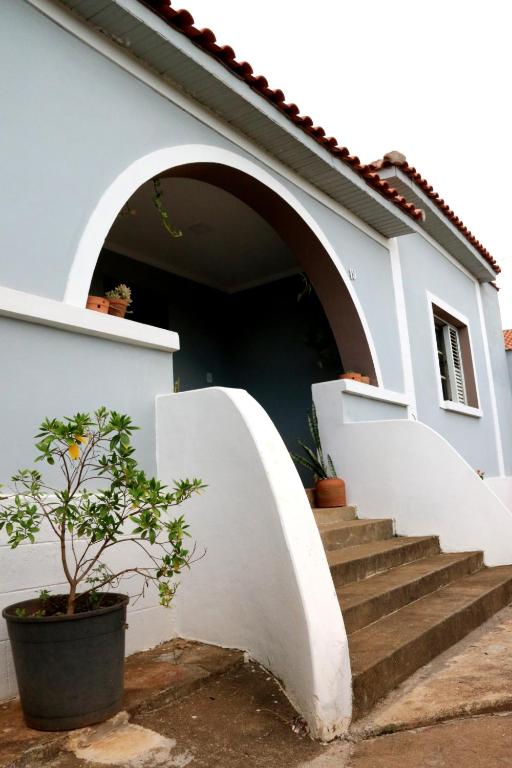 eine Treppe, die zu einem weißen Haus mit einer Tür führt in der Unterkunft Casa dos Arcos Hospedaria in São João Batista do Glória