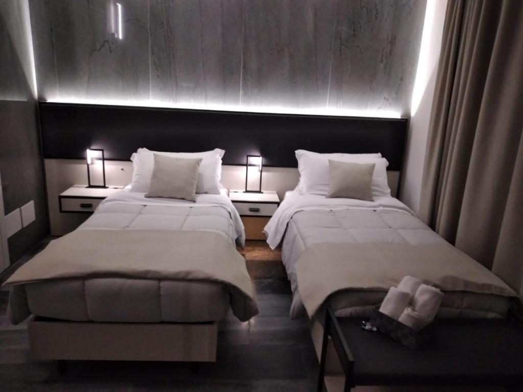 ヴァルモントーネにあるRainbow Sweet Roomsのランプ2つが付いた部屋のベッド2台