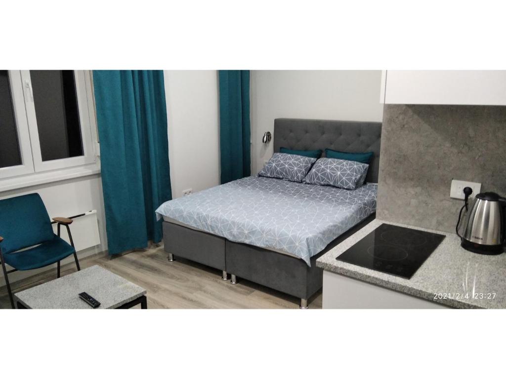 ein kleines Schlafzimmer mit einem Bett und einer Küche in der Unterkunft Slatka Tajna in Banja Luka