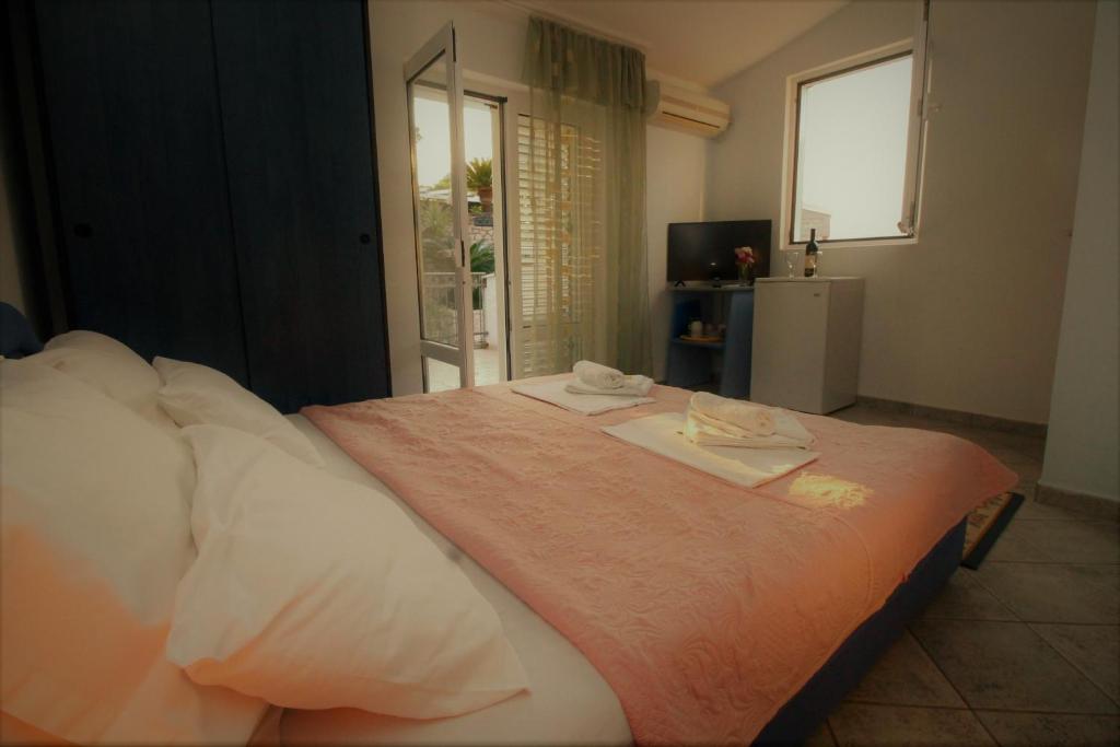 a bedroom with a bed with two towels on it at Apartments Mitrovići Miločer in Sveti Stefan