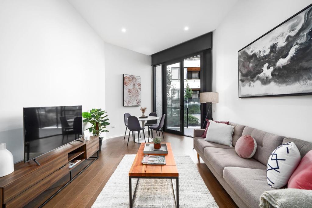 a living room with a couch and a tv at Kerridge St Apartments by Urban Rest in Kingston 