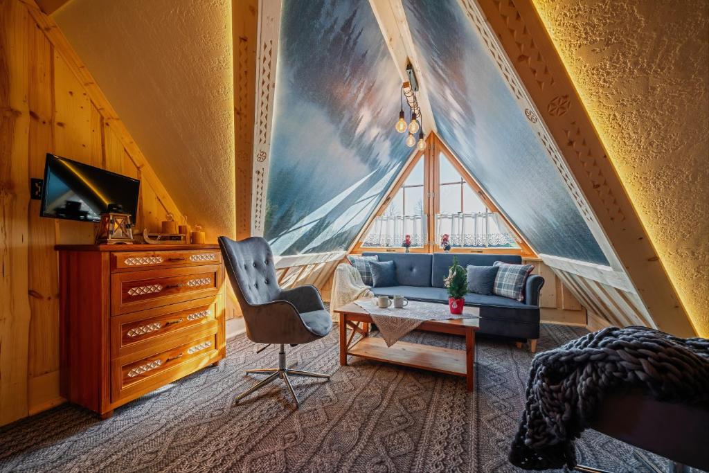 a bedroom with a blue couch and a large window at Willa Pod Niebem in Zakopane