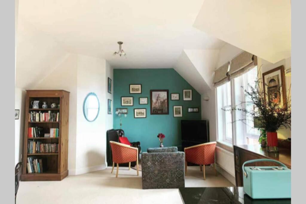 un soggiorno con pareti e sedie con accento verde di Spacious town-centre apartment with stunning views a Great Malvern