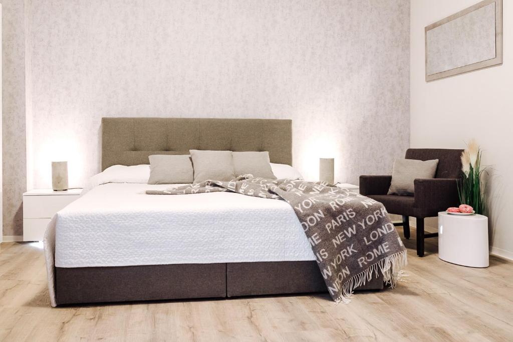 - une chambre avec un grand lit et une chaise dans l'établissement Apartment an der Altstadt (#5), à Hameln