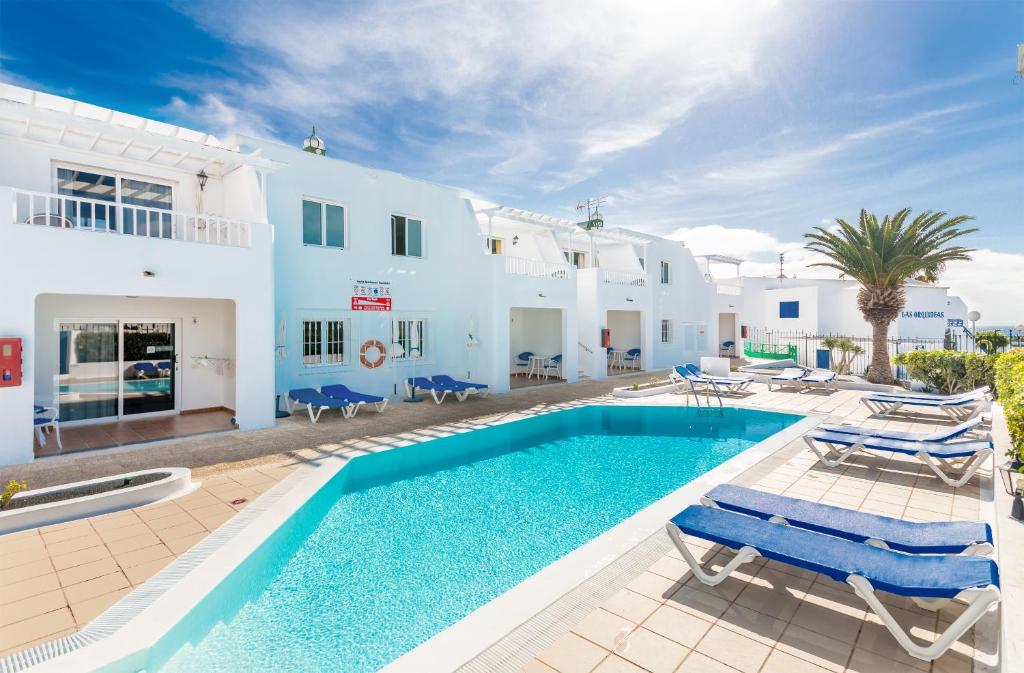 una villa con piscina di fronte a una casa di Cactus a Puerto del Carmen