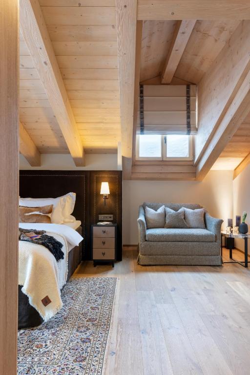 a bedroom with a bed and a couch at Hôtel de Verbier SUP in Verbier
