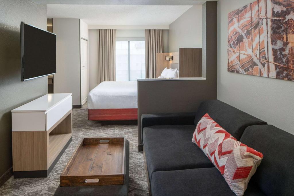 uma sala de estar com um sofá e uma cama em Sonesta Select Nashville Airport Suites em Nashville