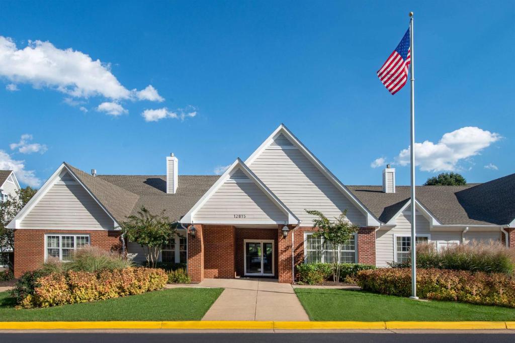 una casa con una bandera americana delante de ella en Sonesta ES Suites Fairfax Fair Lakes en Fairfax