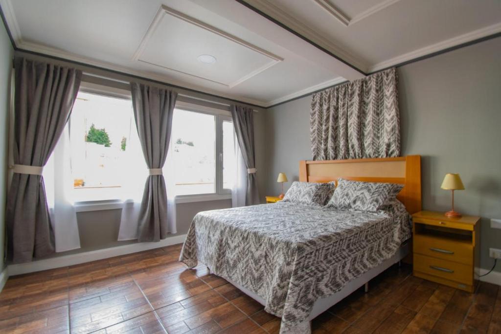 1 dormitorio con cama y ventana grande en ABC DEPARTAMENTOS en Ushuaia