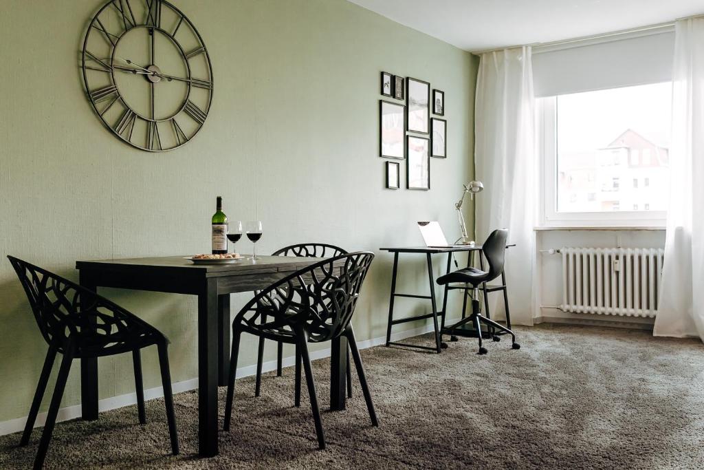 a dining room with a table and chairs and a clock at Apartment in Hameln # Rom in Hameln