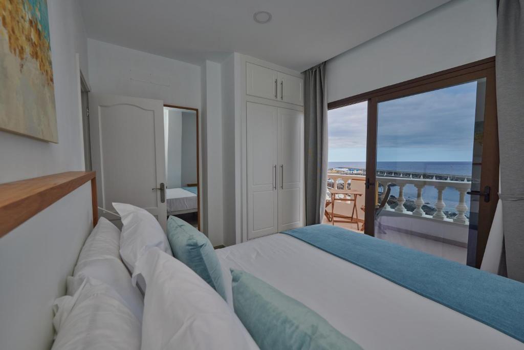 a bedroom with a bed with a view of the ocean at ABLANCAS - La Restinga in La Restinga