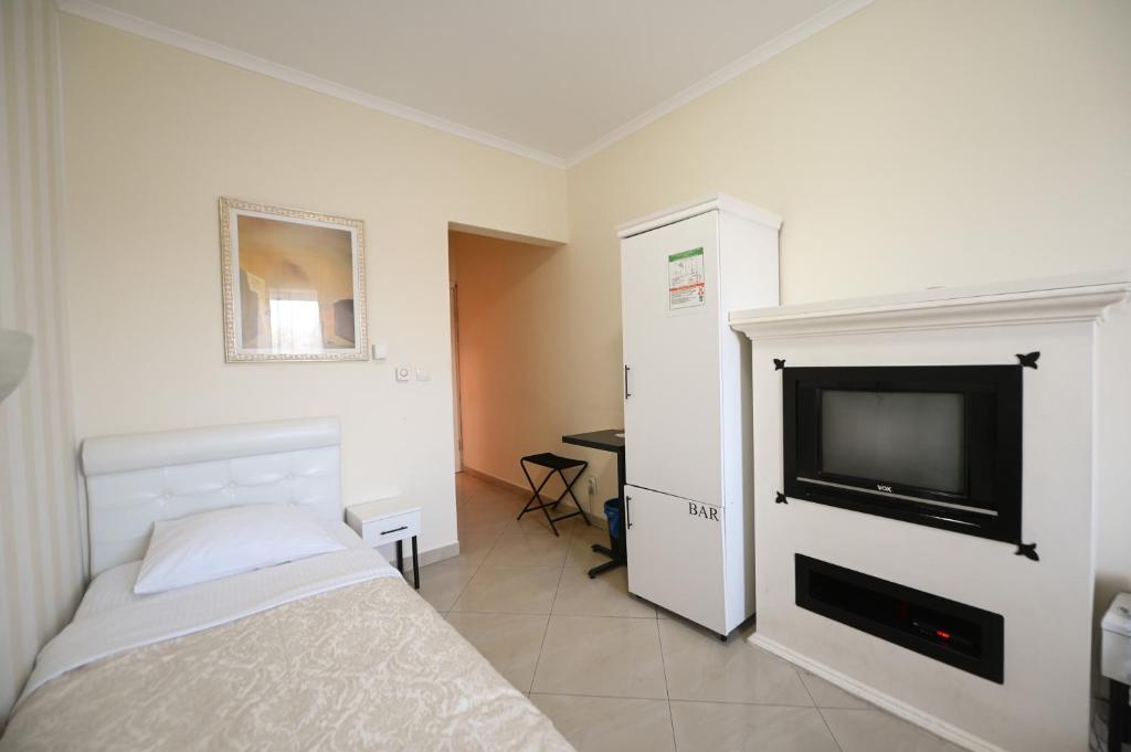 una camera da letto con un letto e una TV a schermo piatto di Garni Hotel Dash a Novi Sad