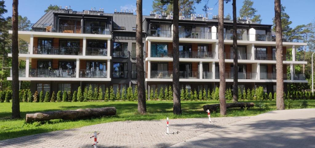 een groot gebouw met bomen ervoor bij Marina Apartments and Jet Ski in Augustów