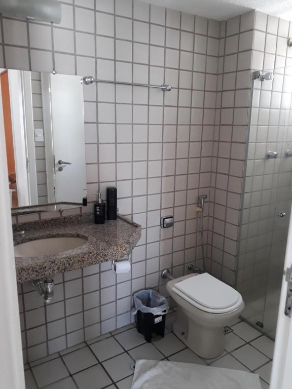 a bathroom with a toilet and a sink and a mirror at JG SILVA HOSPEDAGEM in São Luís