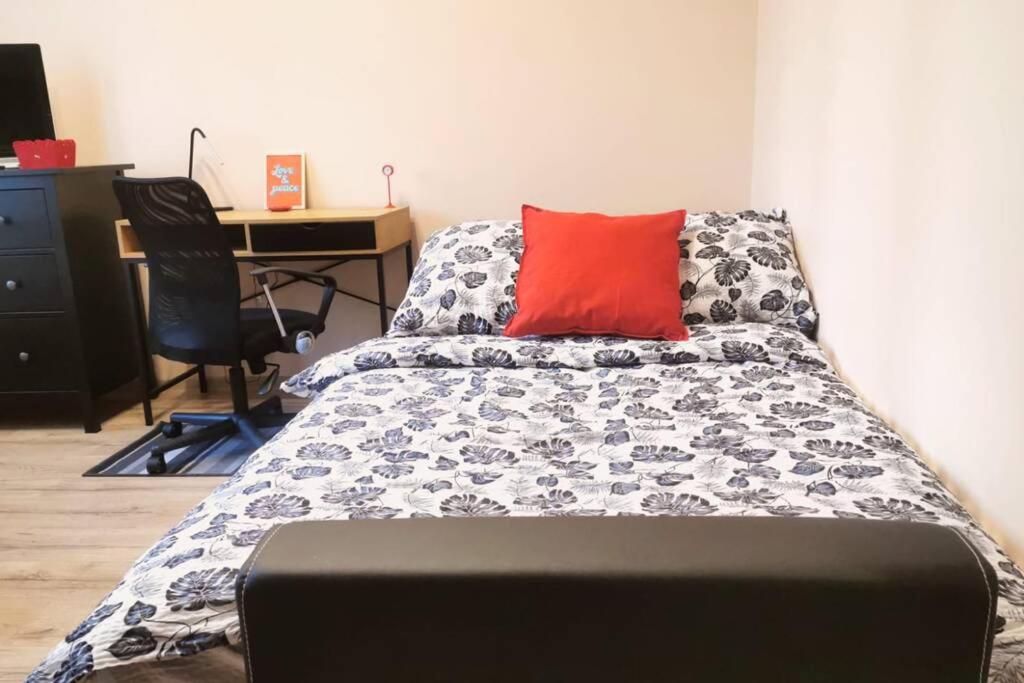 um quarto com uma cama com uma almofada vermelha e uma secretária em Little Big Red - Central Modern Studio em Cracóvia