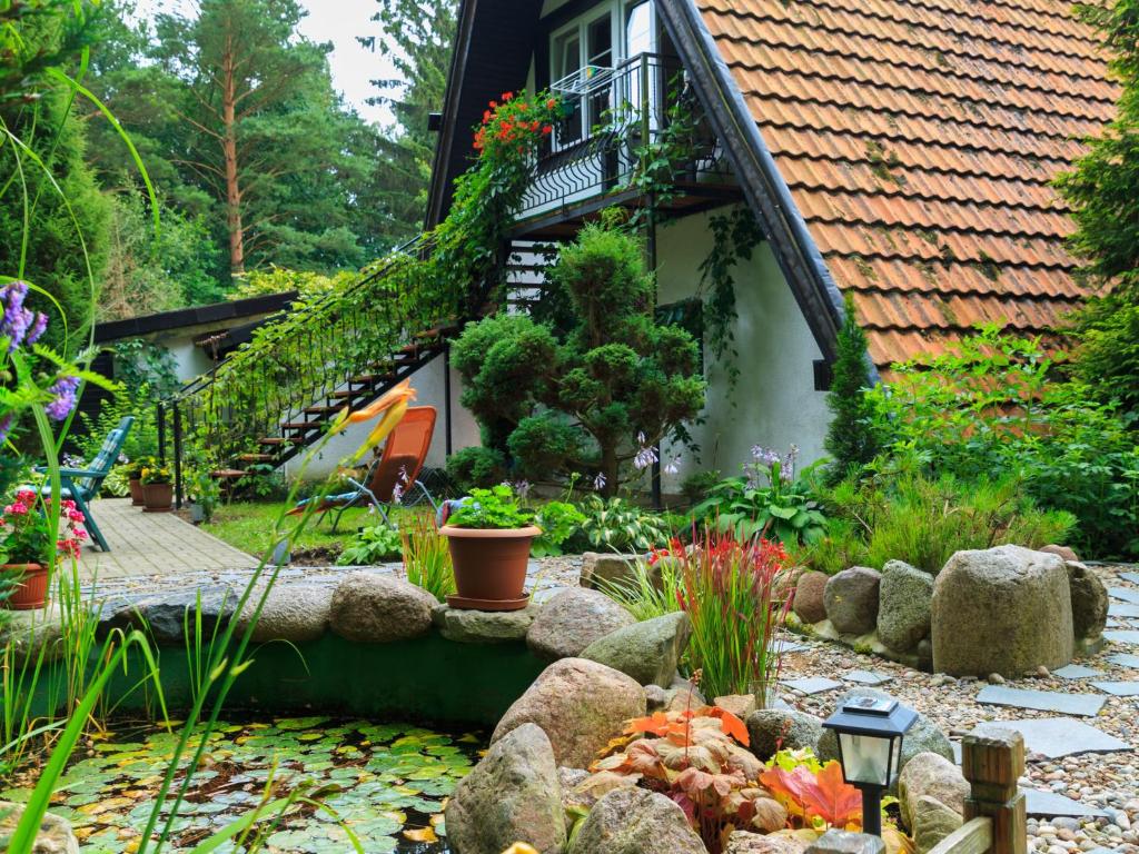 a garden with a pond in front of a house at Lovely Apartment in Rusko with Pool Garden in Darłowo