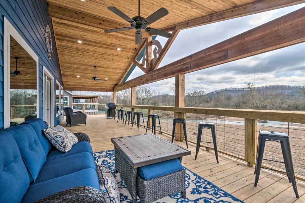 a living room with a blue couch on a deck at Upscale Riverfront Home with Beach and Fire Pit! in Glenwood
