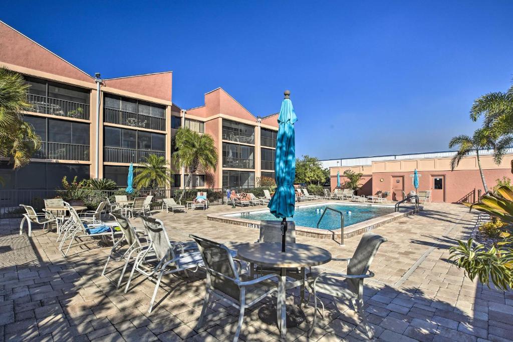 une cour avec une table, des chaises et une piscine dans l'établissement Burnt Store Marina Condo Boat, Swim, Golf!, à Burnt Store Marina