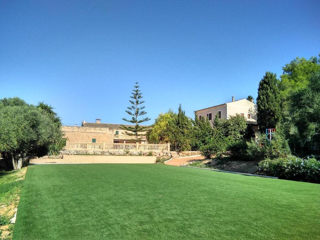 a grassy area with a building and trees at Finca Son Sureda Agroturismo in Manacor