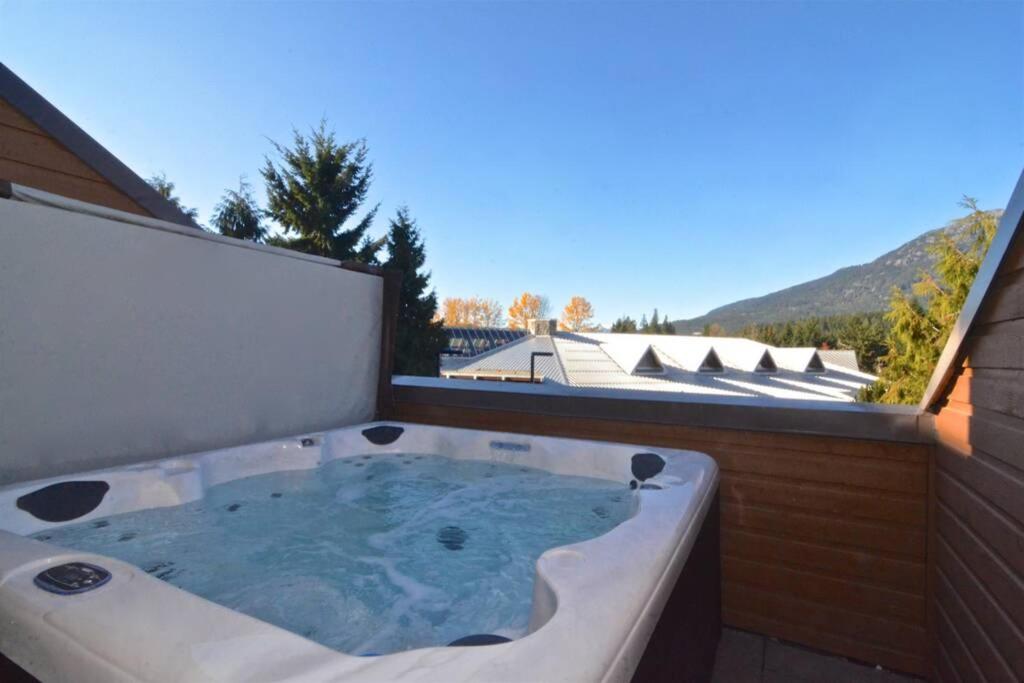a jacuzzi tub on a balcony with a view at Hearthstone Lodge loft, Village centre, Private Hot tub, sleeps 6 in Whistler