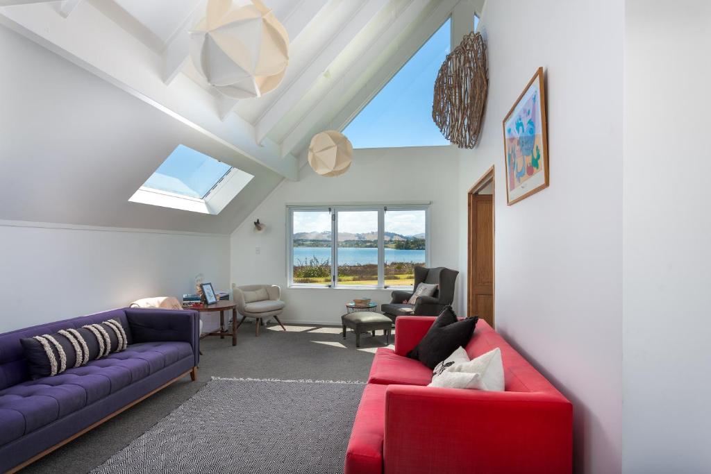 una sala de estar con 2 sofás y una ventana en Sunset Sands Holiday Accomodation, en Waihi Beach