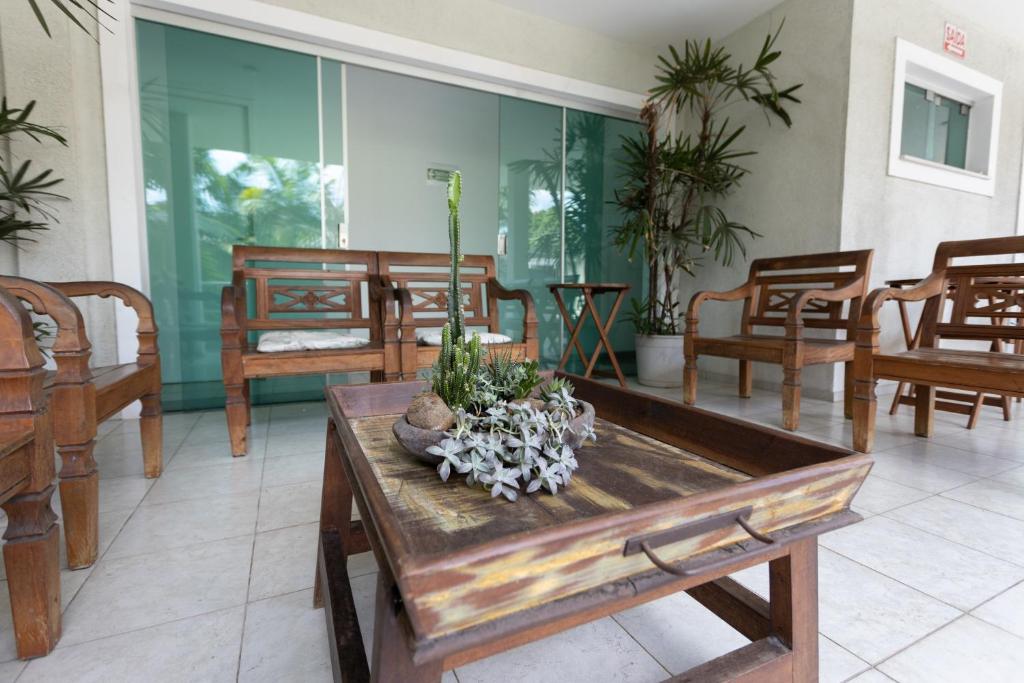 a room with a table with a plant on it at Pousada Palmeira Real in Itaguaí