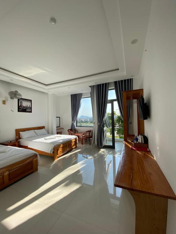 um quarto com duas camas e uma televisão em Queen Hotel em Tuy Hoa