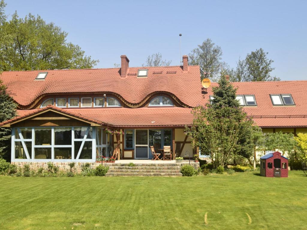 a large house with a red roof and a yard at Villa with beautiful nature Lovely garden sauna in Karwieńskie Błoto Pierwsze