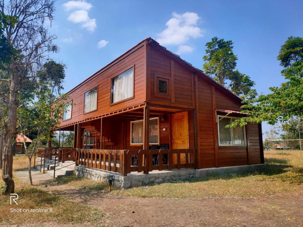 a large wooden house with a porch at LABDHI RESORTS Stag Groups not allowed in Masinagudi