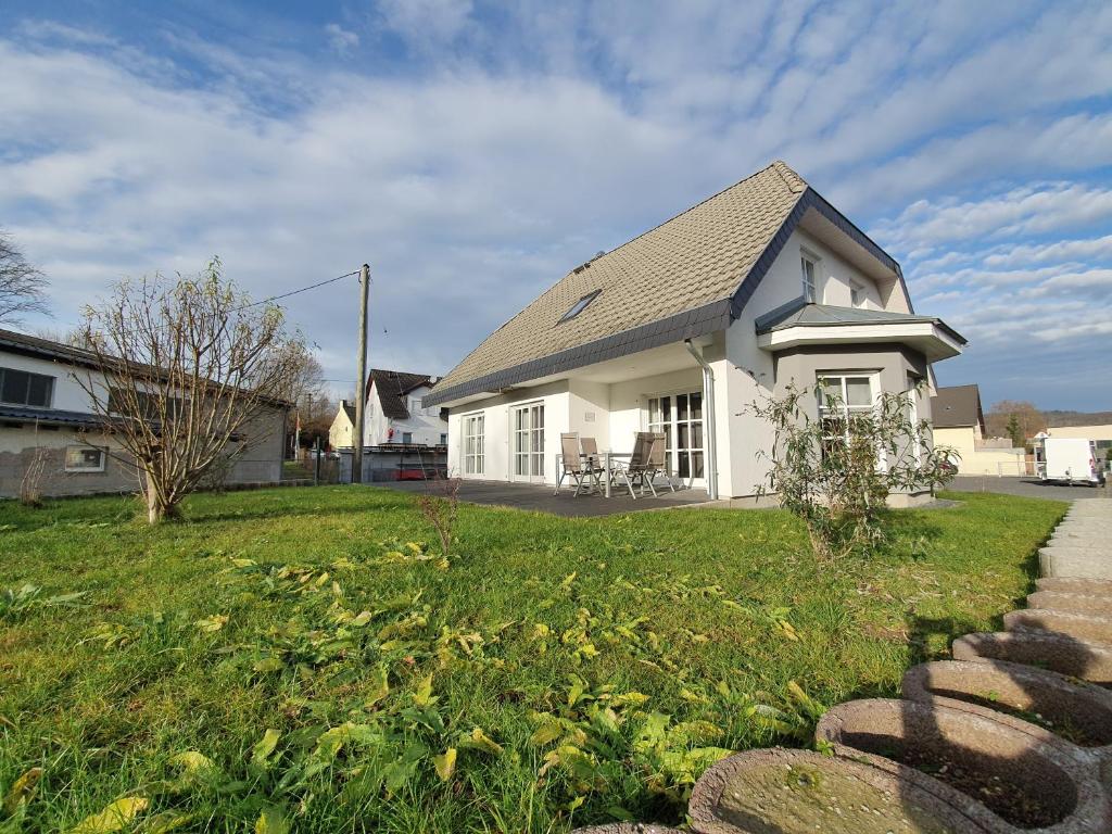 una pequeña casa blanca con un patio de césped en Gästehaus Alte Giesserei, en Bendorf