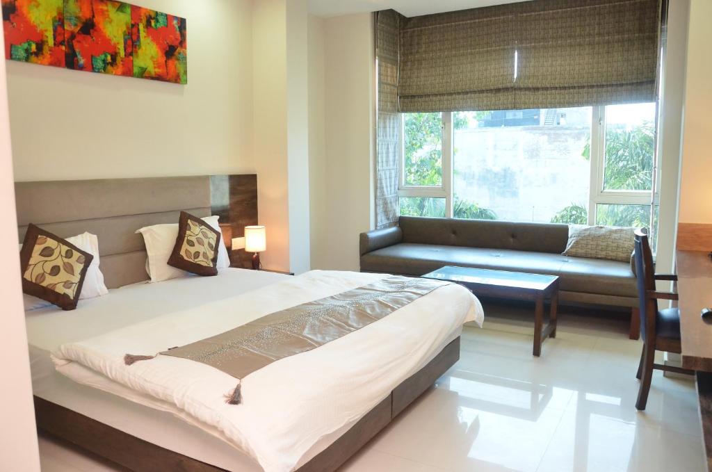 1 dormitorio con 1 cama y 1 sofá en Hotel Sopan Heights en Nueva Delhi