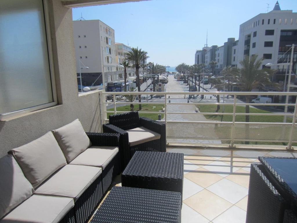 d'un balcon avec des canapés et une vue sur la rue. dans l'établissement Arena Résidence, au Cap d'Agde