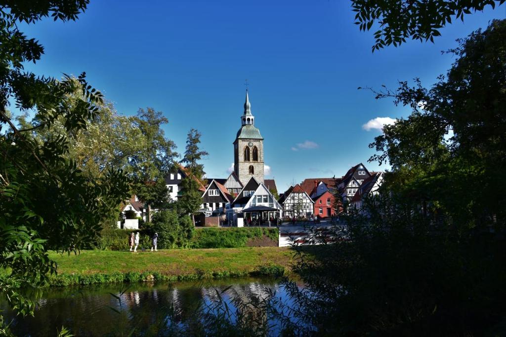 eine Stadt mit einer Kirche, einem Fluss und Bäumen in der Unterkunft Ratskeller Wiedenbrück in Rheda-Wiedenbrück