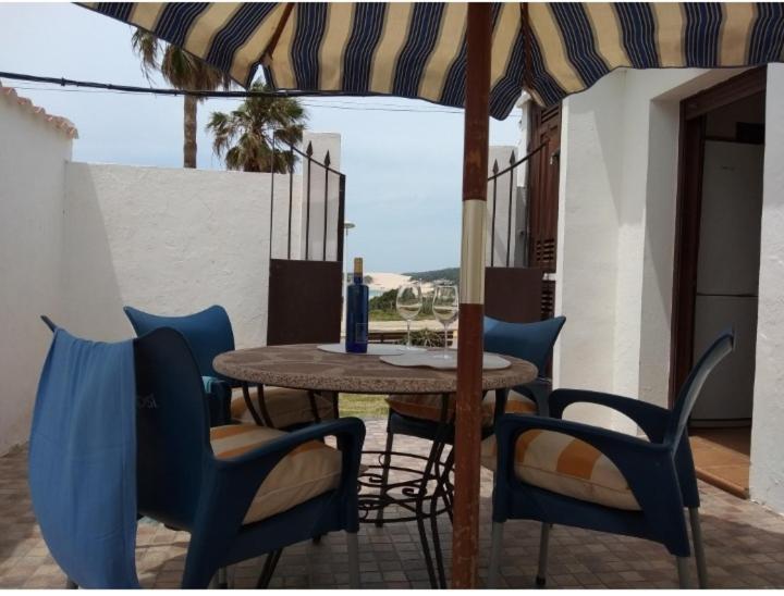 a table with chairs and an umbrella on a patio at El Rincón de Bolonia in Bolonia