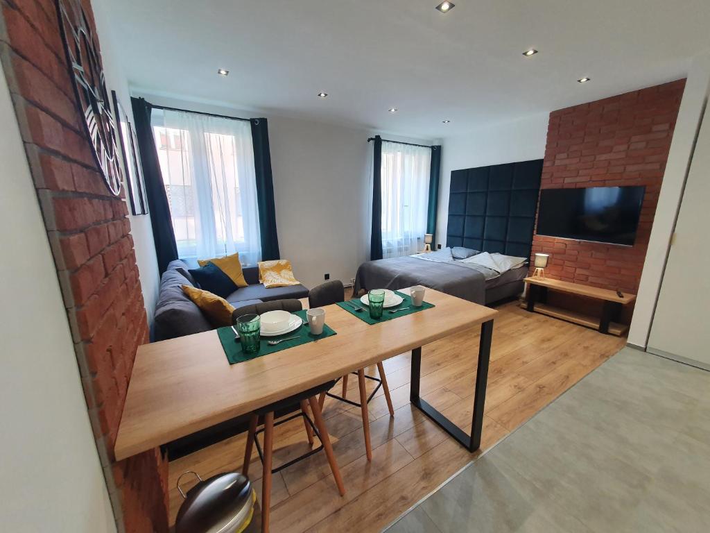 ein Wohnzimmer mit einem Tisch und einem Sofa in der Unterkunft Mirror Apartments in Oświęcim