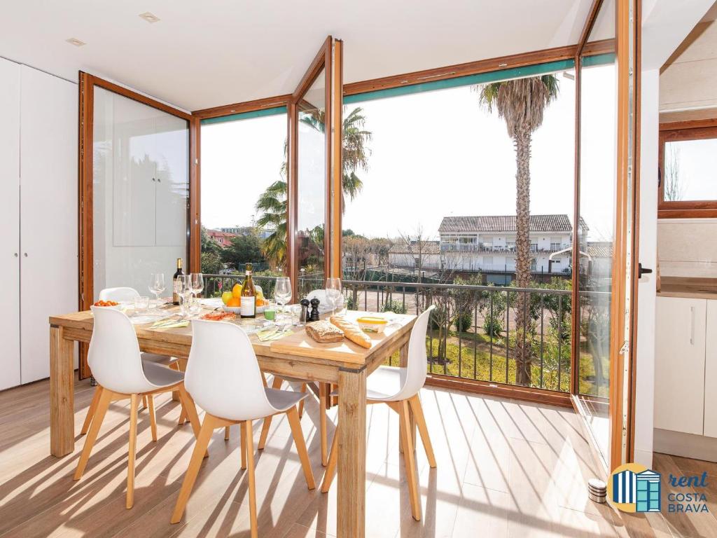 a dining room with a table and chairs and a large window at Apto Las Palmeras in Platja  d'Aro