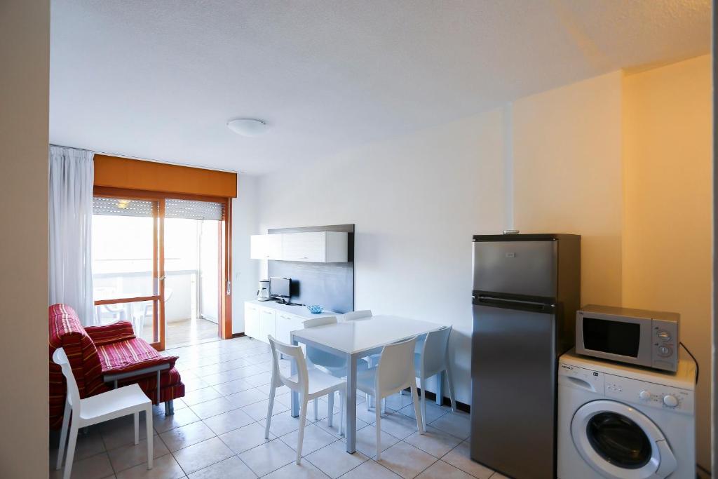 una cucina e una sala da pranzo con tavolo e frigorifero di Residence Holiday a Porto Santa Margherita di Caorle