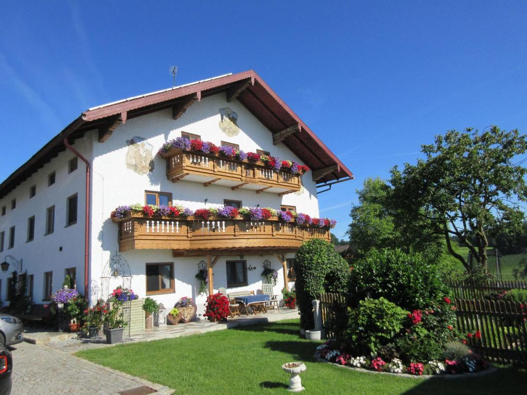 a building with a balcony with flowers on it at Feichtlhof in Taching am See