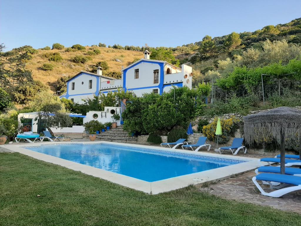 a villa with a swimming pool in front of a house at El Rincon de Carmen in Rute