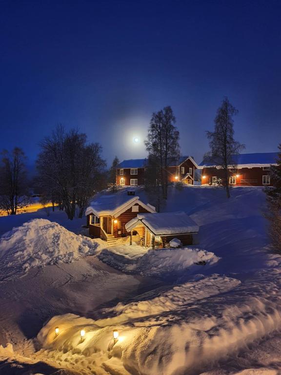 a house is covered in snow at night at Backamgården in Sälen