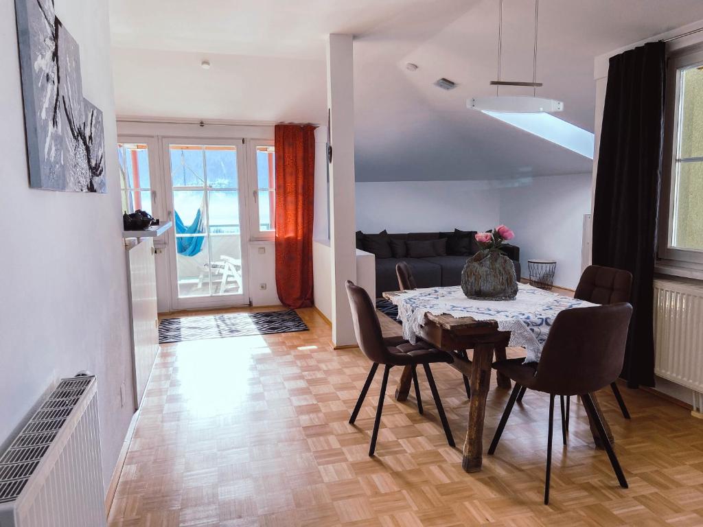 ein Esszimmer mit einem Tisch, Stühlen und einem Sofa in der Unterkunft Ferienwohnung Karasek mit Seeblick in Sattendorf