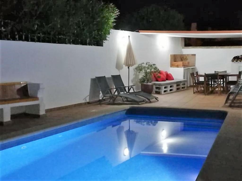 una piscina in un cortile con tavolo e sedie di LEIDA - Relax y privacidad a Cala Blanca