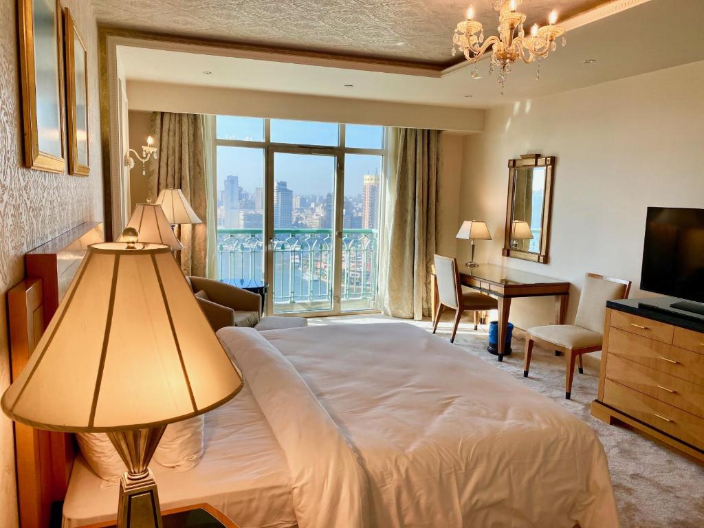 a hotel room with a large bed and a desk at Chez Haytham At Four Seasons Nile Plaza Residential Suite in Cairo